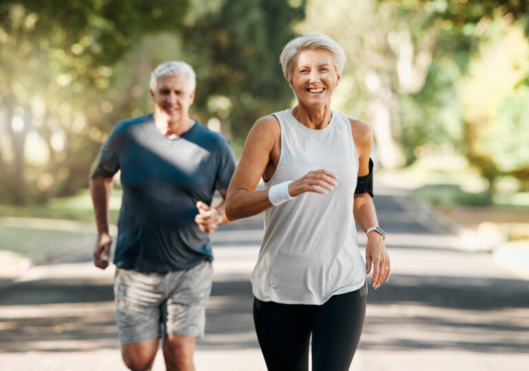 Pareja madura corriendo juntos al aire libre