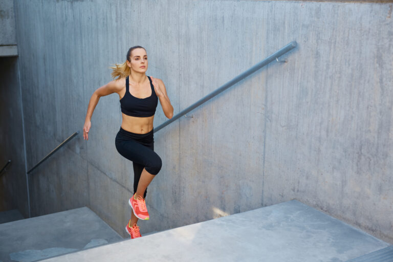 Mujer deportista subiendo escaleras al aire libre